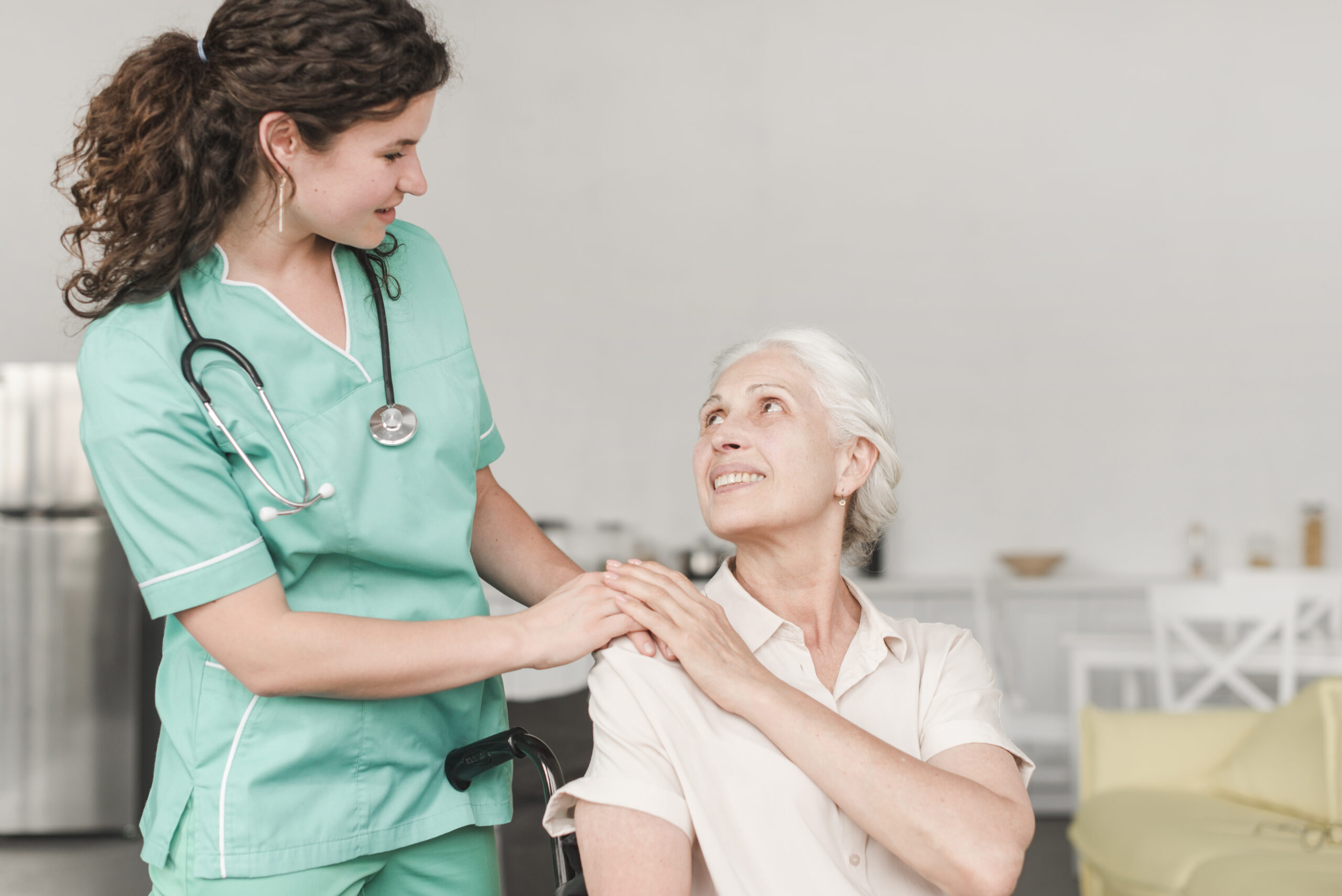 nurse-giving-help-disabled-female-senior-patient-sitting-wheelchair